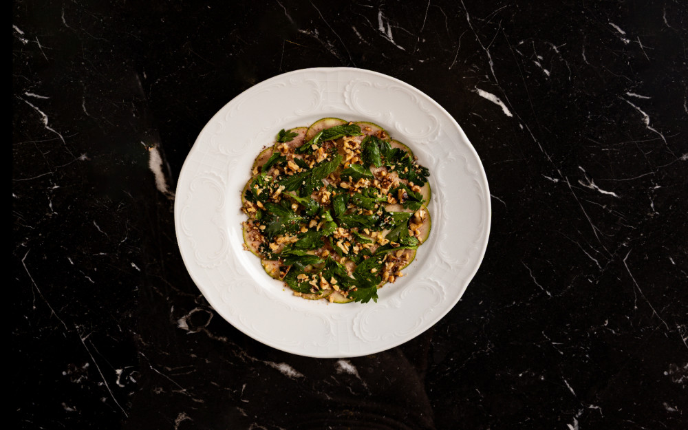 A crisp composition of market greens, toasted nuts, and delicate herbs