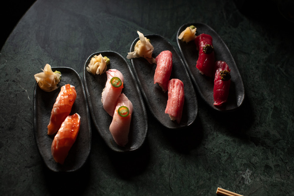 Close-up of assorted nigiri sushi—Salmon + Ikura, Yellowtail + Jalapeño, Toro + Soy, Tuna + Caviar at Double Knot Miami.