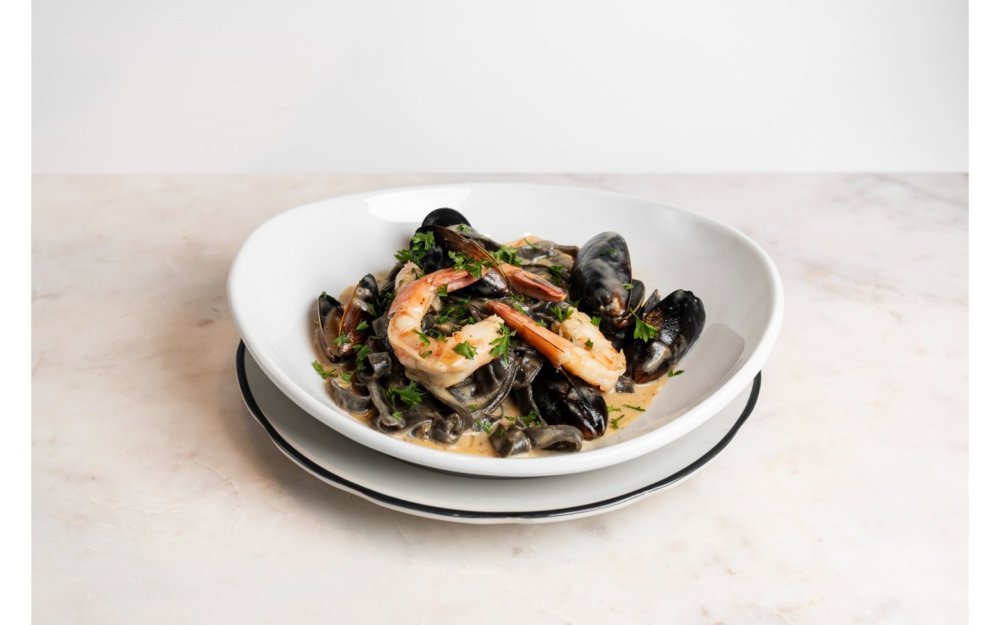 con mejillones y camarones en salsa crema de vino blanco, limón y pimiento verde.