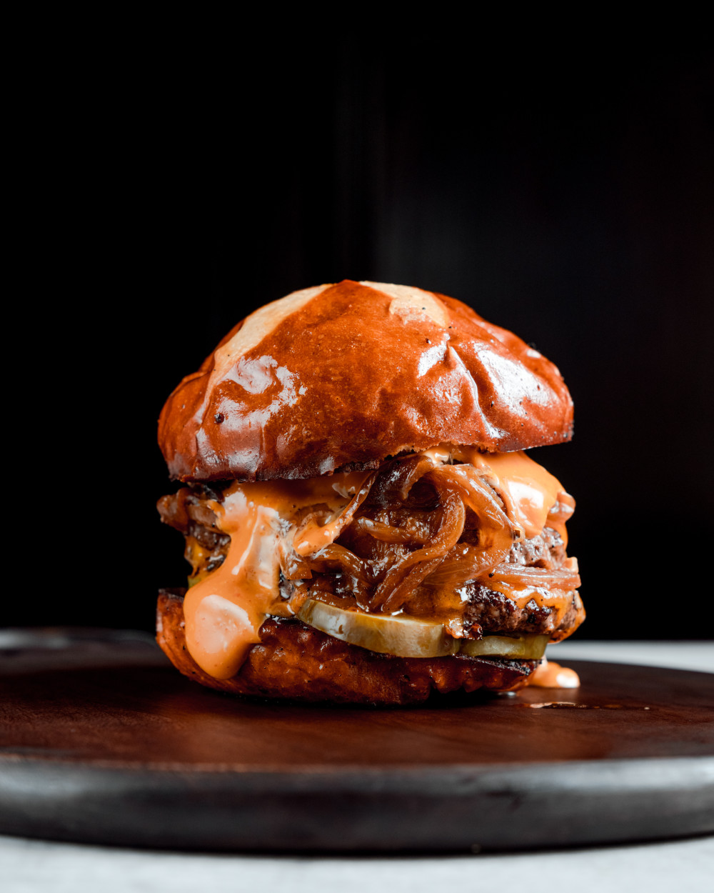 Two 1/4Ib. AmSO beef blend patties, cheddar, smash sauce, pickel, caramelized onion, pretzel bun.