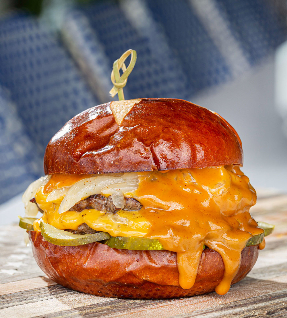 Two 1/4Ib. AmSO beef blend patties, cheddar, smash sauce, pickle, caramelized onion, pretzel bun