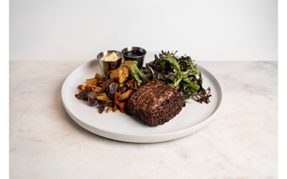 8 Oz, sellado en granos de pimienta negra, con ensalada y mezcla de papas asadas.
