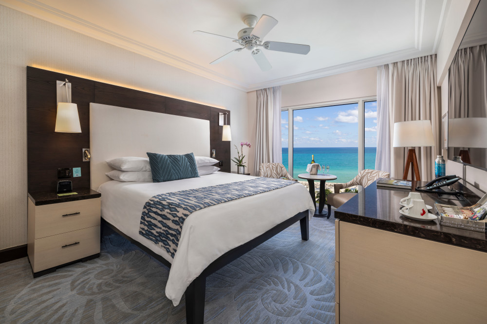 Oceanfront King guestroom with full Atlantic views, floor-to-ceiling windows, coastal décor, and a cozy seating area—steps from Miami Beach at The Pal