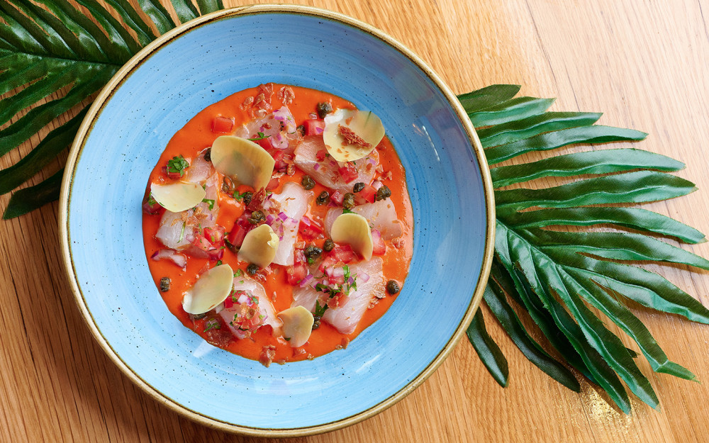 Tiradito Mediterraneo - Corvina, artichoke confit, piquillo leche de
tigre, crispy serrano, chalaquita, and capers.