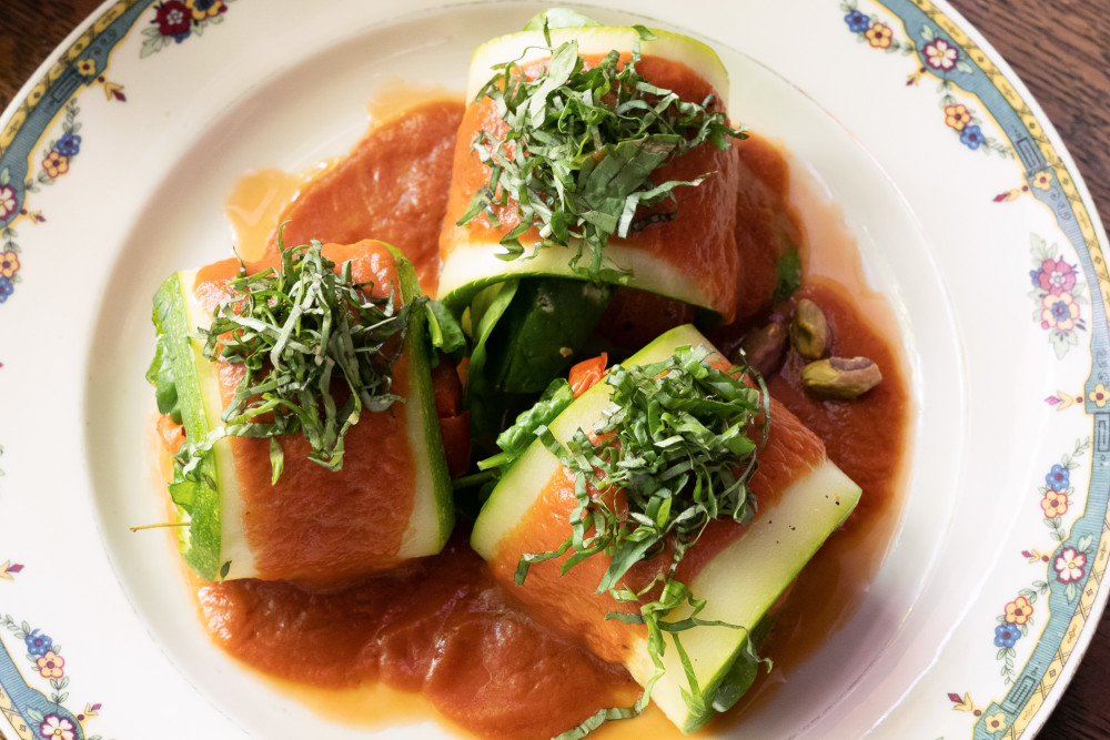 Baked zucchini rolls, stuffed with fresh spinach, goat cheese, pistachios and tomato sauce