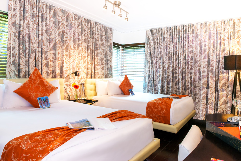 Lavishly appointed Two Queens guest room is furnished with a modern flare. A white, leather oversized bed frames sit above Tempurpedic mattresses, accompanied by all-white bedding, complete with 300 thread count sheets and orange accents. The rooms feature hardwood floors, two queen size beds, and includes the most up-to-date entertainment system, complete with a wall-mounted 42-inch plasma TV with satellite service, in-room safe, and mini-refrigerator. Guests can indulge in secluded luxury and an array of amenities in South Beach's most 
unique setting.