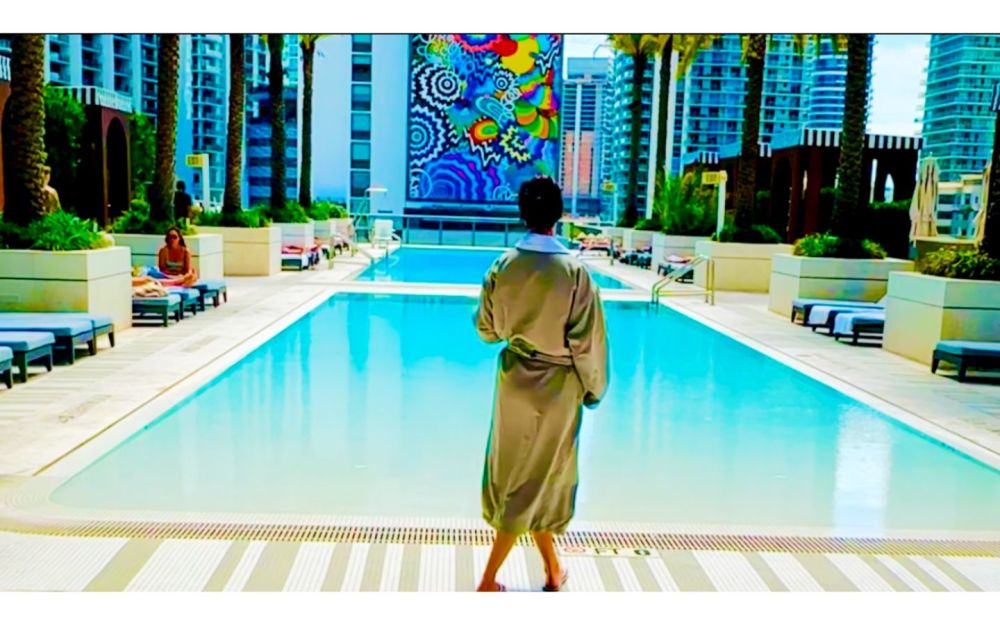 穿着水疗浴袍的顾客走向 SLS LUX 酒店的屋顶泳池 Hotel ，享受 Lux MedSpa Brickell 的豪华健康疗养体验