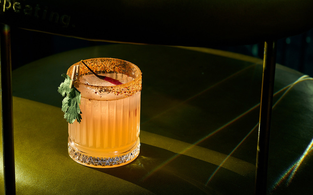 A margarita at Giselle Miami featuring a spiced rim, citrus garnish and fresh herbs