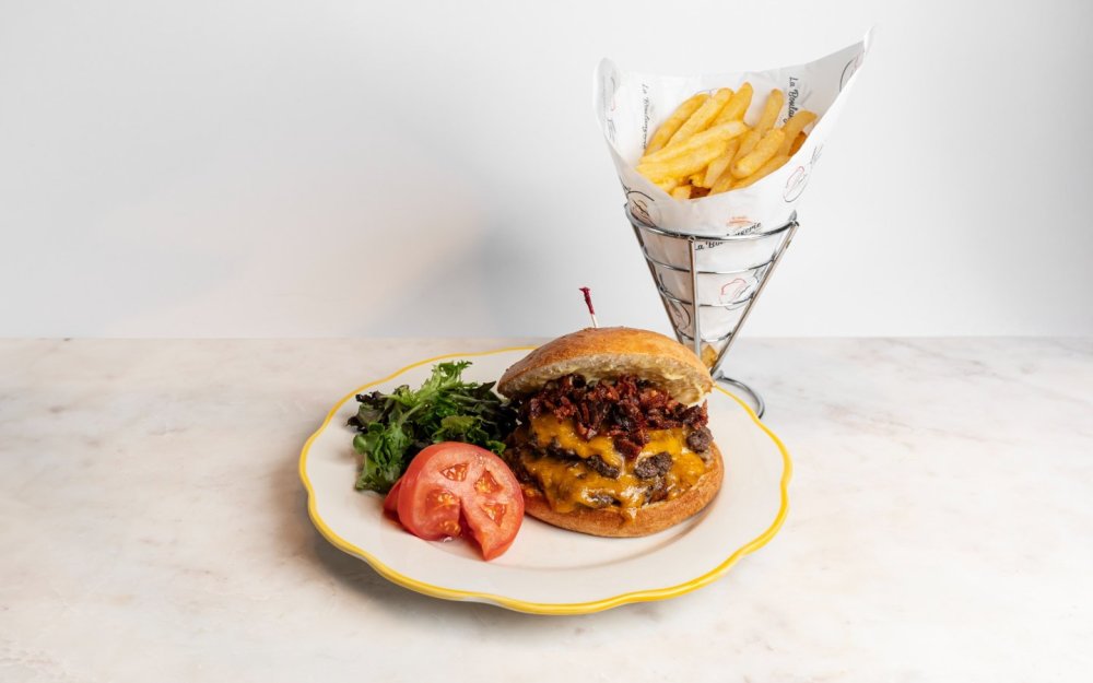 Lechuga, tomate, cebolla roja, queso americano, tocino, con papas fritas.