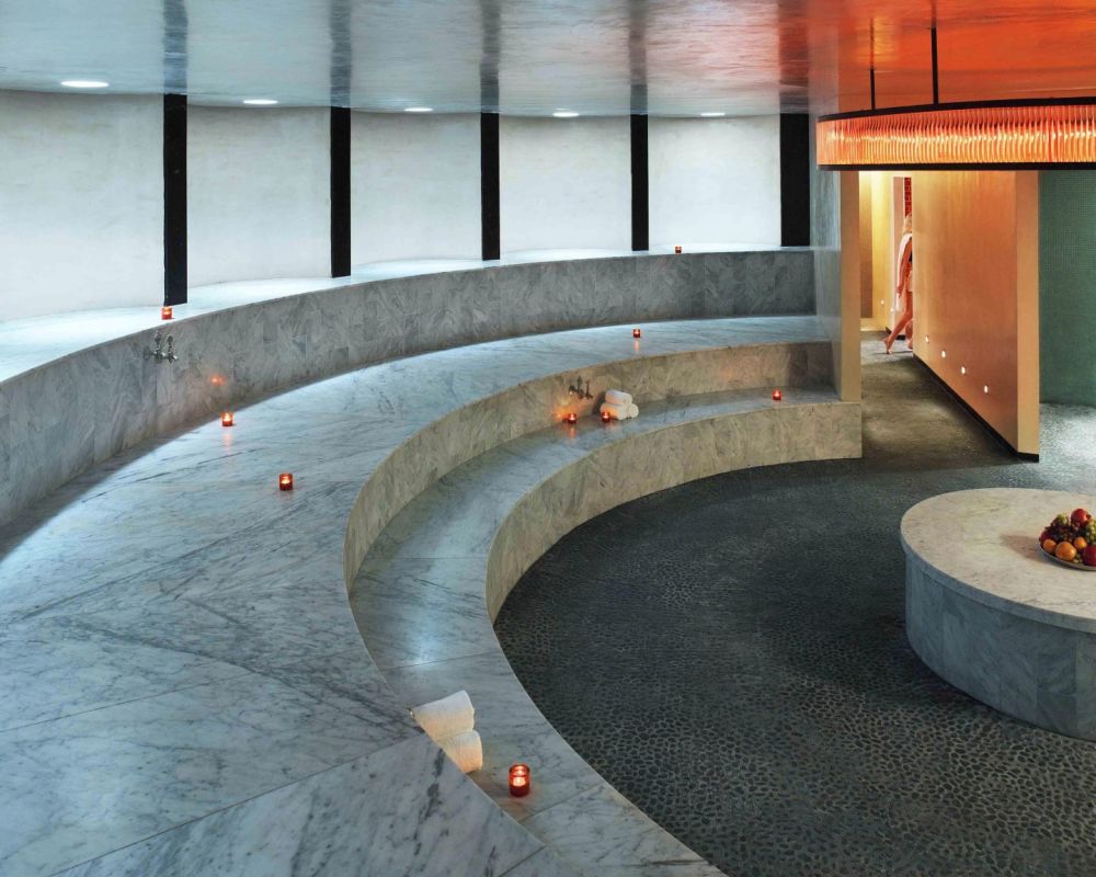 The Hamam at The Standard Spa features curved marble seating, soft candlelight and a serene setting designed for relaxation and renewal.