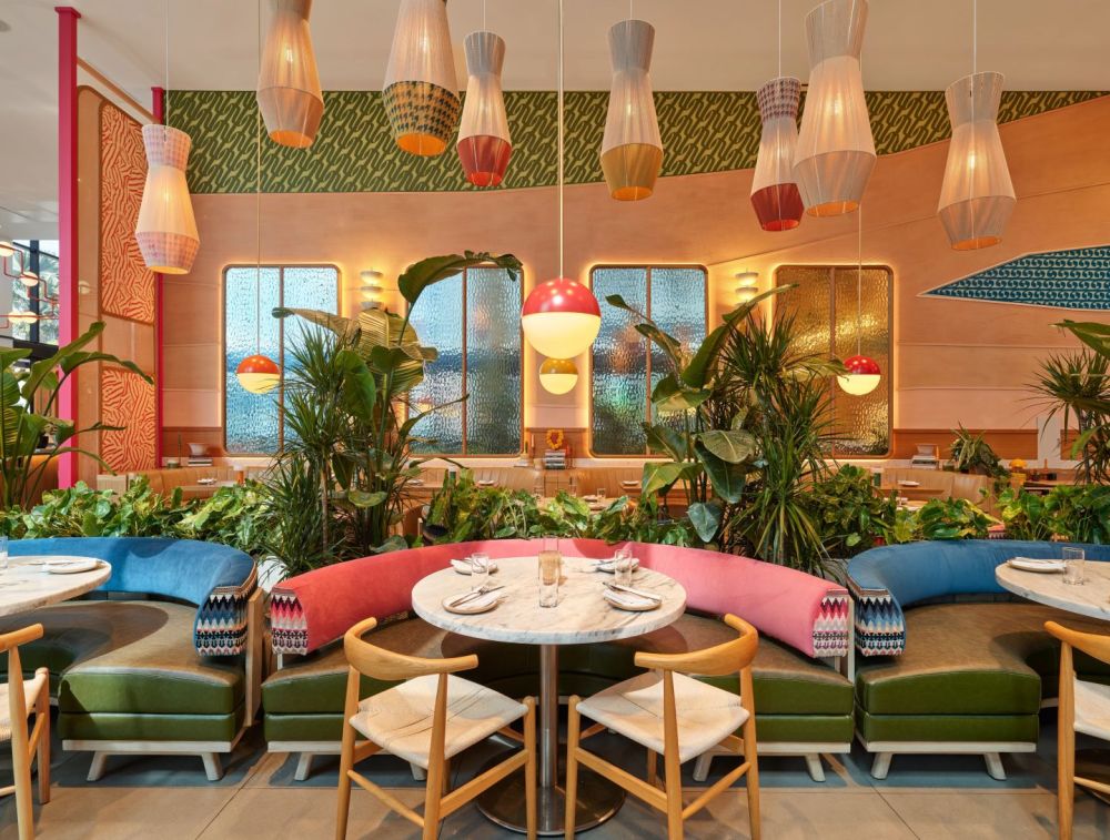 The colorful dining room at Wyn Wyn features vibrant décor, lush greenery and inviting seating.
