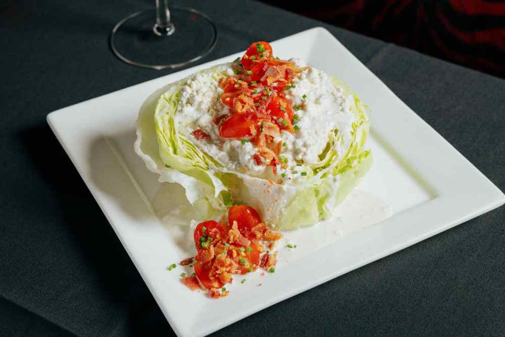 iceberg lettuce / bacon / cherry tomatoes / bleu cheese crumbles / crispy onions / bleu cheese dressing