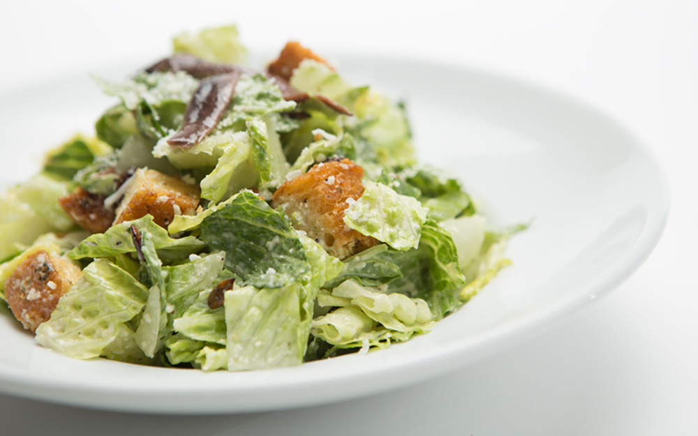 Romaine lettuce tossed with a creamy Caesar dressing, Romano cheese, roasted pumpkin seeds, homemade croutons and anchovies