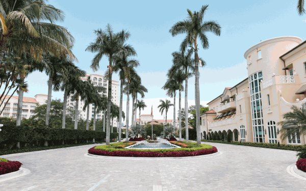 You're greeted by the picturesque driveway of a waterfall, swaying palm trees, and vibrant flowers that takes you to valet or self-parking garage.