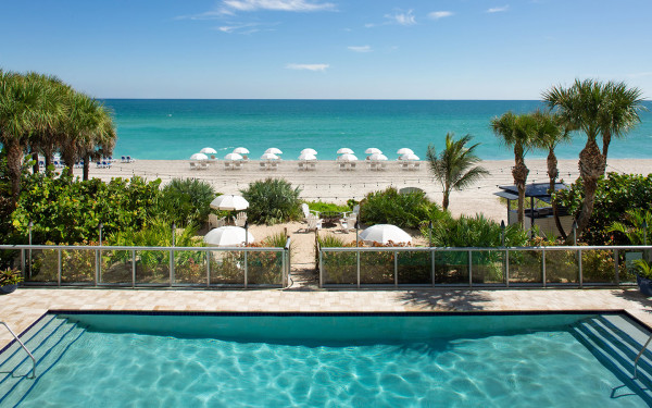 Relax in the sunshine at our beachfront pool, just steps from azure waters and the white sand beaches of Sunny Isles.
