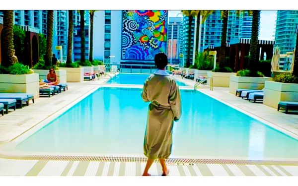 穿着水疗浴袍的顾客走向 SLS LUX 酒店的屋顶泳池 Hotel ，享受 Lux MedSpa Brickell 的豪华健康疗养体验