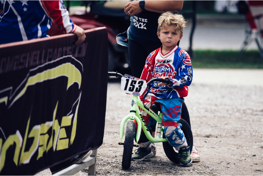 A young BMX racer waits his turn at the starting line.