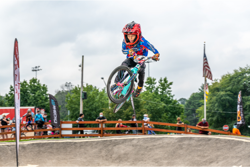 A young BMX racer jumps a hill and catches major air.