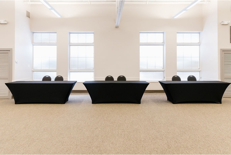 3 tables with black tablecloths