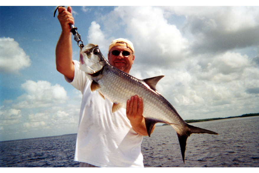 Man holding up a freshly-caught Tarpon during a Fishing Tournament on Charlotte Harbor