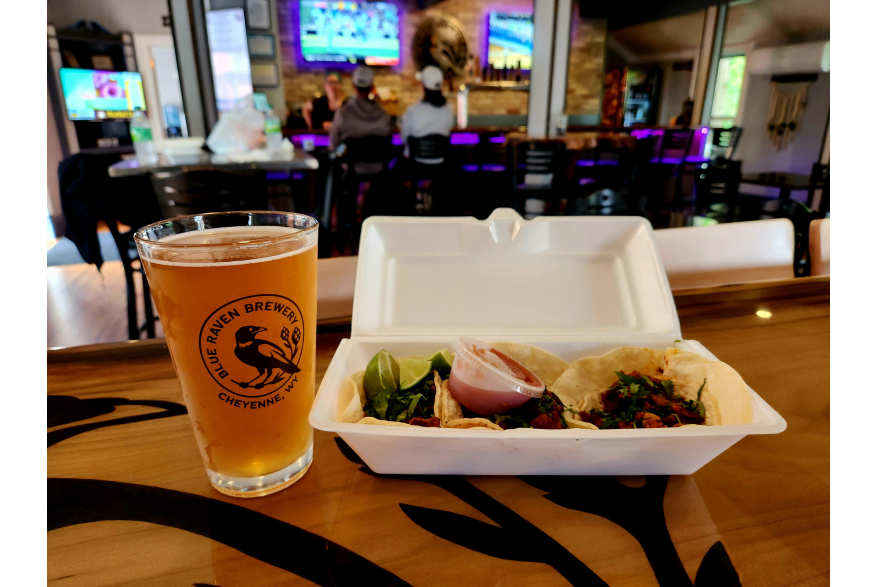 Tacos and a pint of golden ale with the Blue Raven Brewy logo on the.
