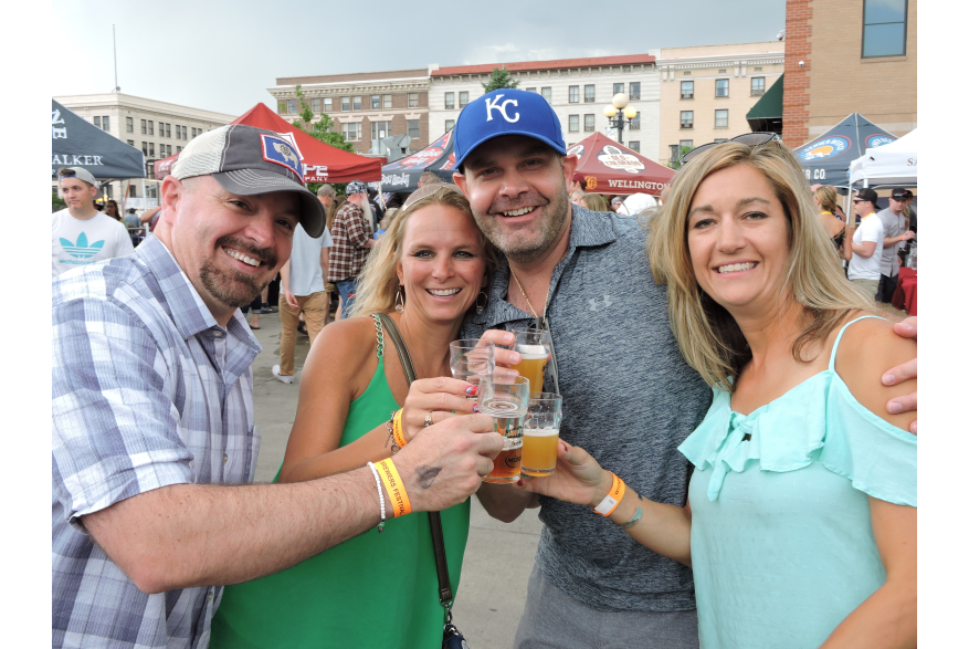 two men and two women enjoying beer at the brewers festival