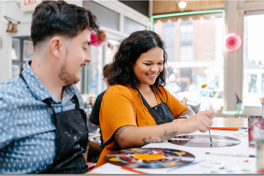 a man watches a woman painting