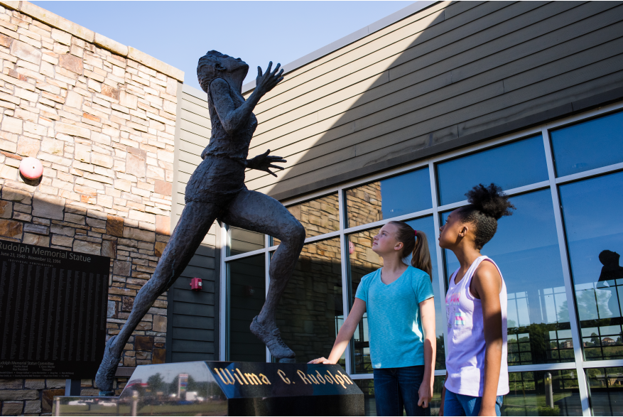two girls admire the Wilma Rudolph statue