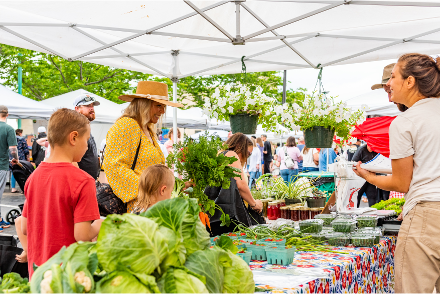 People enjoying stands at the Clarksville Farmers Market.