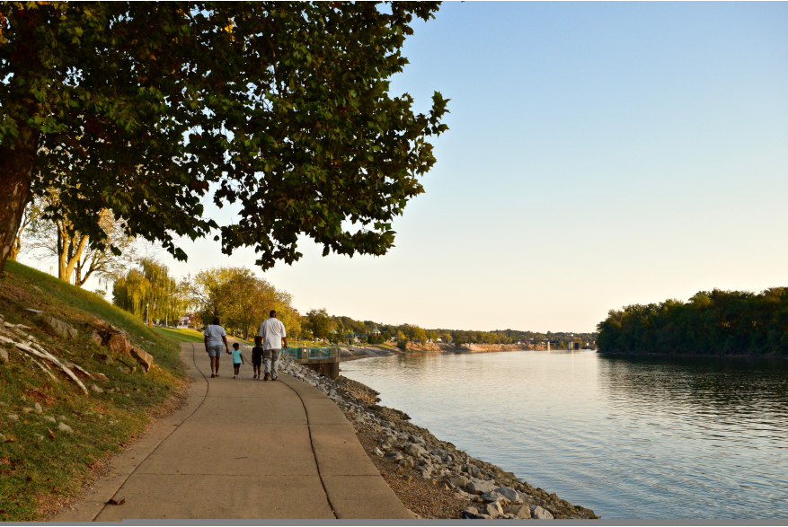 family walking along a riverwalk in the early fall