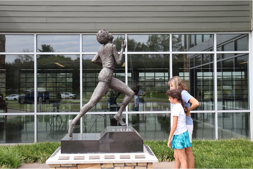 mom and daughter at a bronze statue of Wilma Rudolph