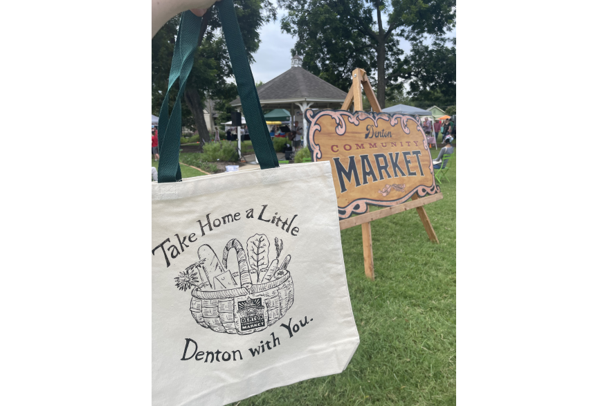 A canvas bag reading "Take Home a Little Denton with You" at Denton Community Market