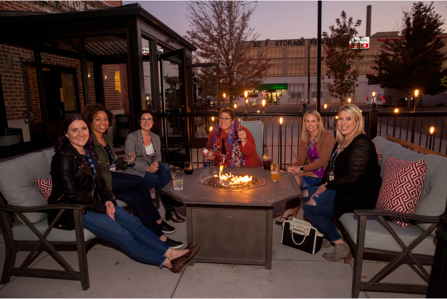 attendees sitting around bonfire outside