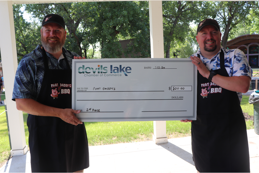 Two men holding a check for second place in Ribfest 2024.