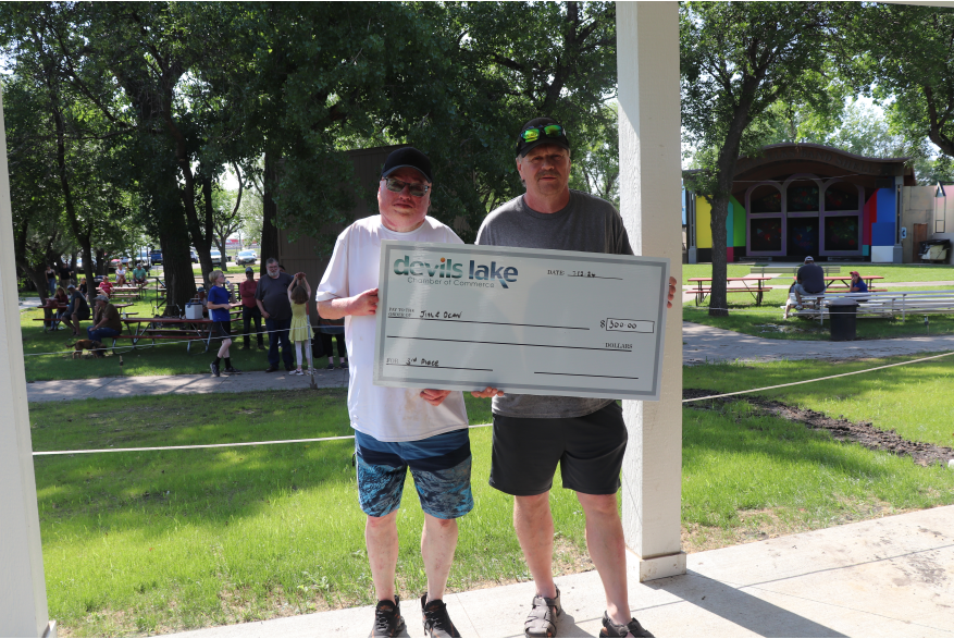 Two men, holding a check for third place at Ribfest.