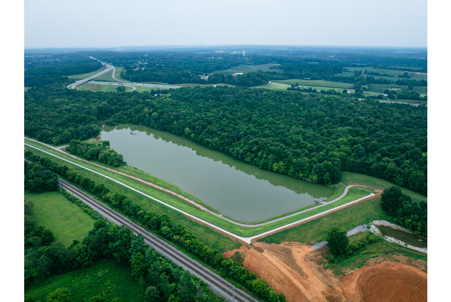 Lake surrounded by greenery and wooded areas, with paved hiking trails at Buffalo Lake in Elizabethtown, Kentucky
