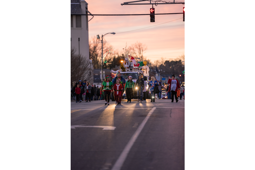 people walking in the christmas parade for lighting up downtown