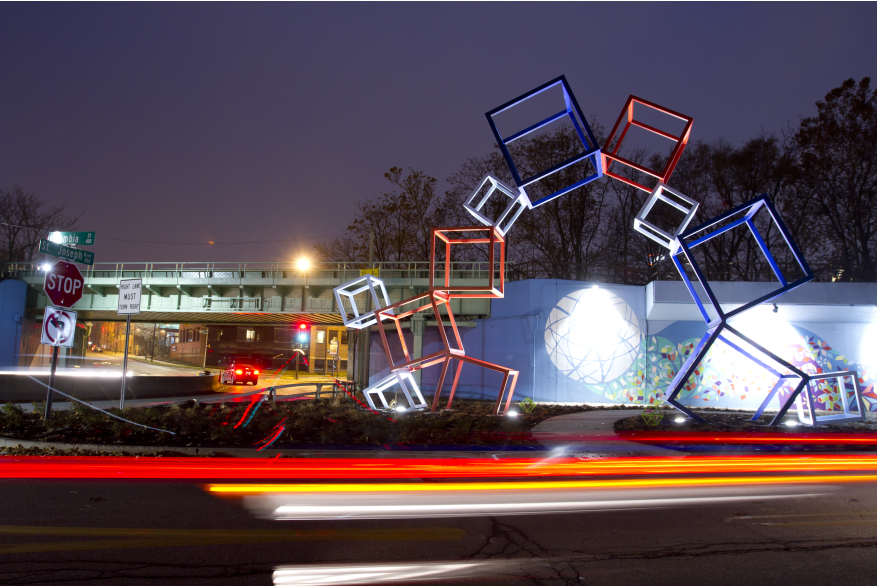Metaform sculpture and mural at night