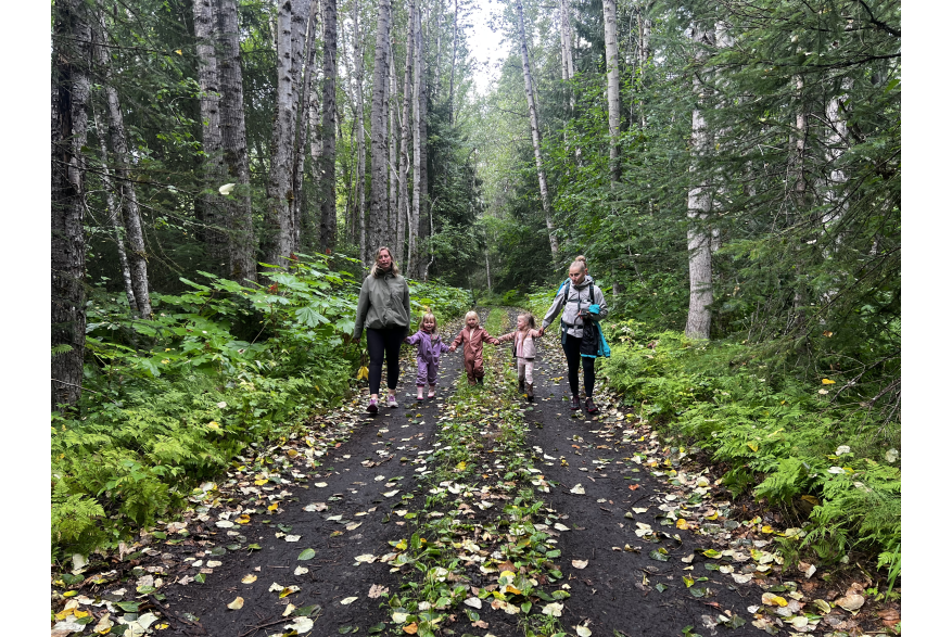 Children walking a trial with moms, fall leaves