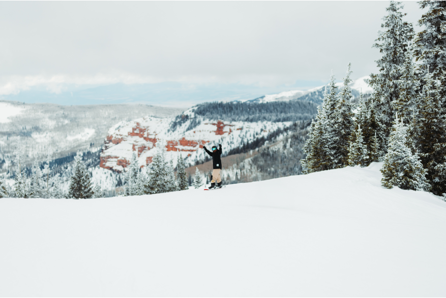 Snowboarding at Brian Head Resort with beautiful red rock in the background.