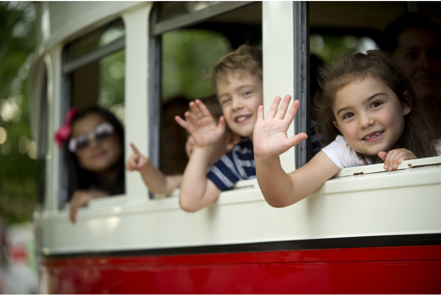 kids waving from the streetcar windows