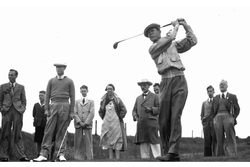 Man golfing with spectators in the background