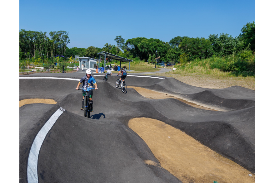 2 riders on bikes using the pump track