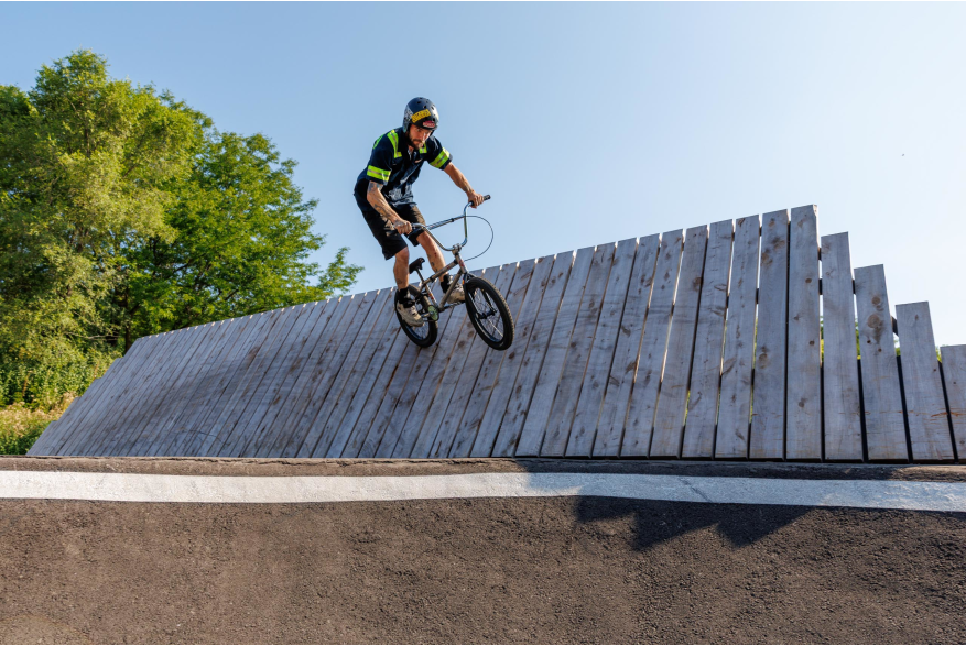Rider up on curved wall at pump track