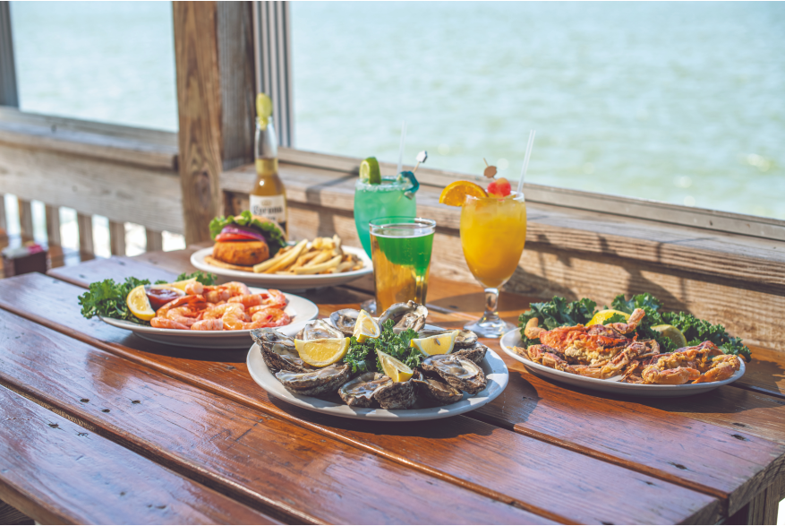 Seafood and colorful drinks with the water in the background
