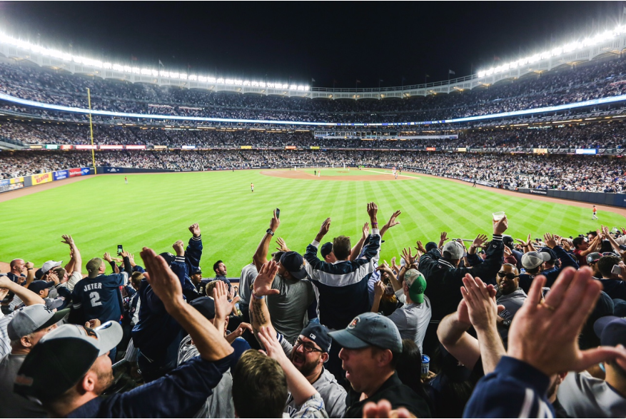 Nighttime game at Yankees stadium with fans cheering