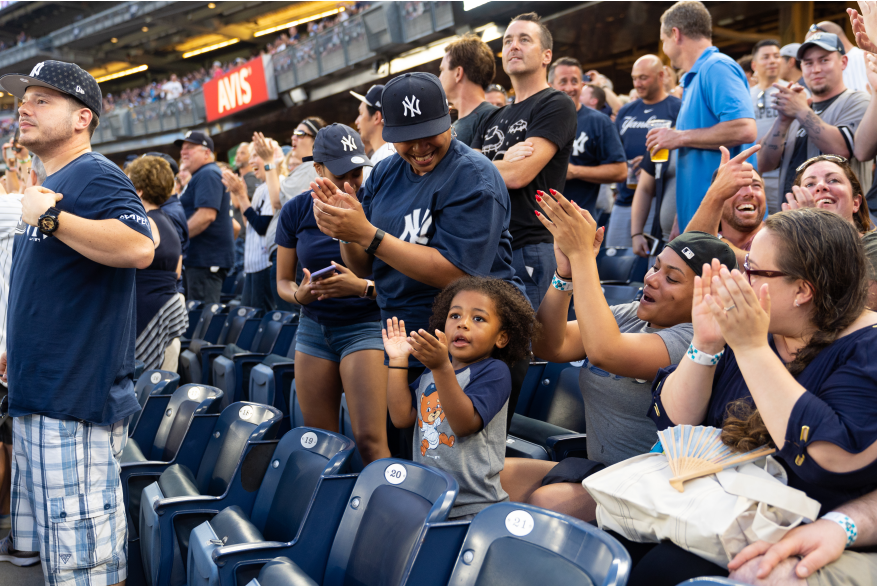 Yankees fans standing to cheer during a game