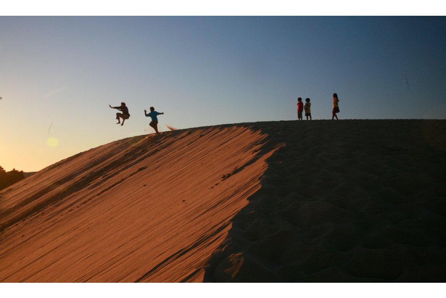 children having fun on a sand dune