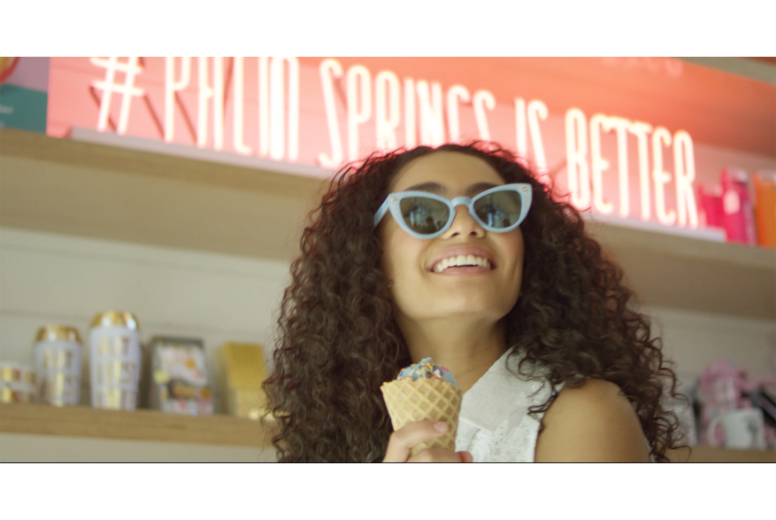 Girl eating ice cream with sunglasses on.