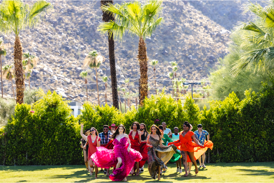 Group of drag queens running on the lawn.